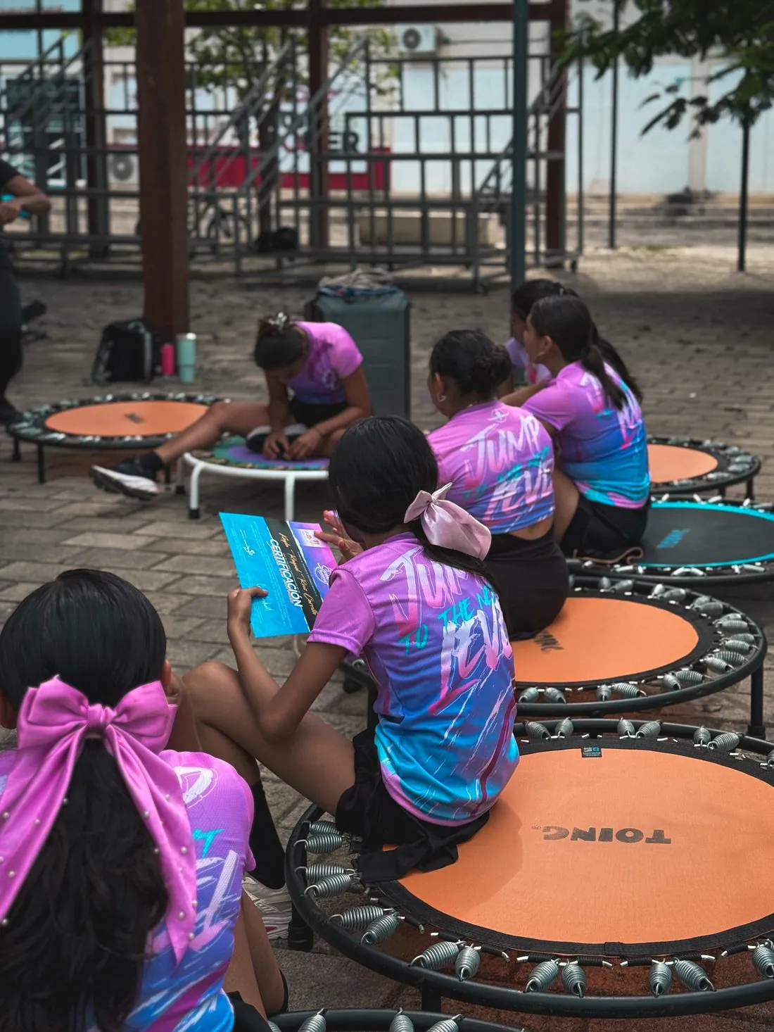 Instructoras con la playera de temporada sentadas en sus trampolines